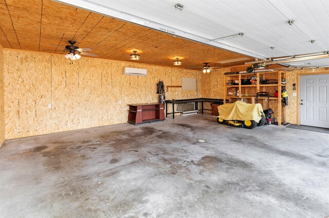 1808 Payton Ave, Des Moines, IA 50315 - garage with a wall mounted air conditioner, a ceiling fan, a workshop area, and wooden walls