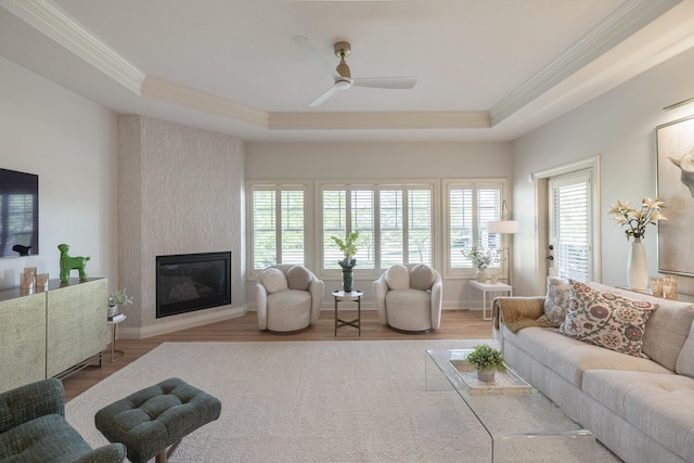 255 S 41st St Unit 171, West Des Moines, IA 50265 - living area with crown molding, wood finished floors, a ceiling fan, a tray ceiling, and a fireplace