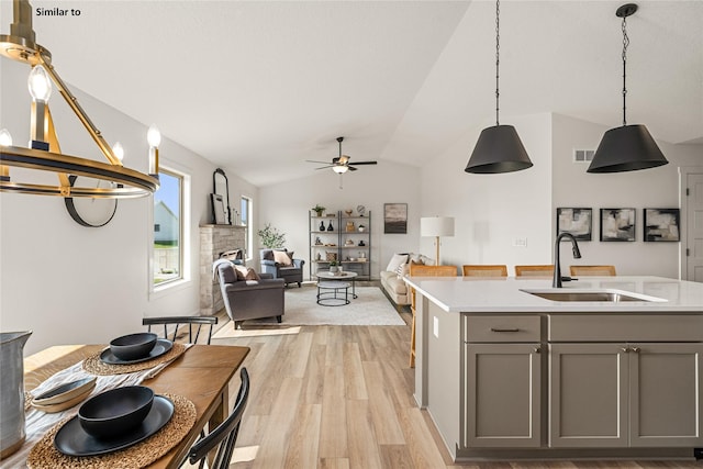1620 NW Jackson Dr, Ankeny, IA 50023 - kitchen featuring gray cabinetry, light wood-type flooring, ceiling fan, light countertops, and vaulted ceiling