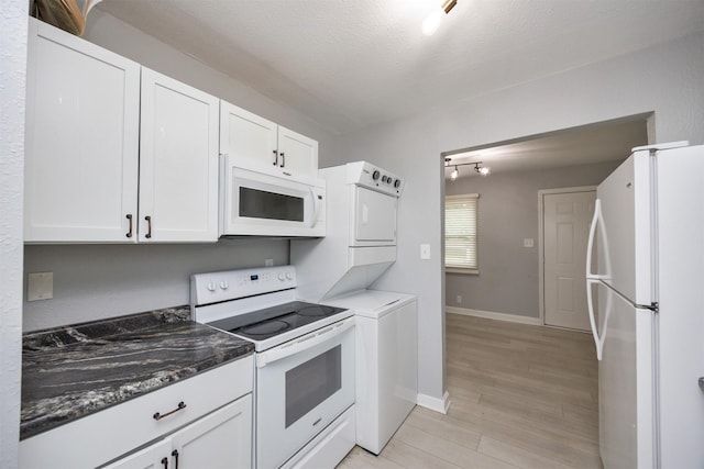 3416 Garfield Ave, Des Moines, IA 50317 - kitchen with white appliances, stacked washer / drying machine, white cabinets, light wood finished floors, and a textured ceiling