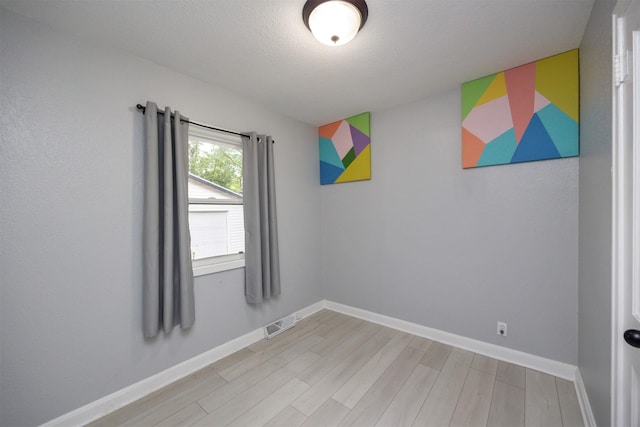 3416 Garfield Ave, Des Moines, IA 50317 - spare room featuring light wood-style floors and a textured ceiling