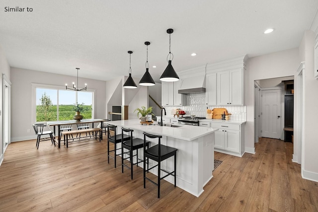 2281 Green Leaf Cir, Norwalk, IA 50211 - kitchen featuring decorative backsplash, stove, light countertops, a breakfast bar area, and white cabinets