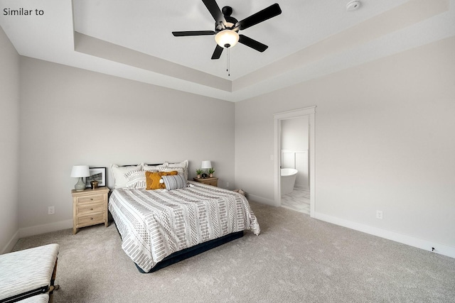 2281 Green Leaf Cir, Norwalk, IA 50211 - carpeted bedroom with a raised ceiling, connected bathroom, and a ceiling fan