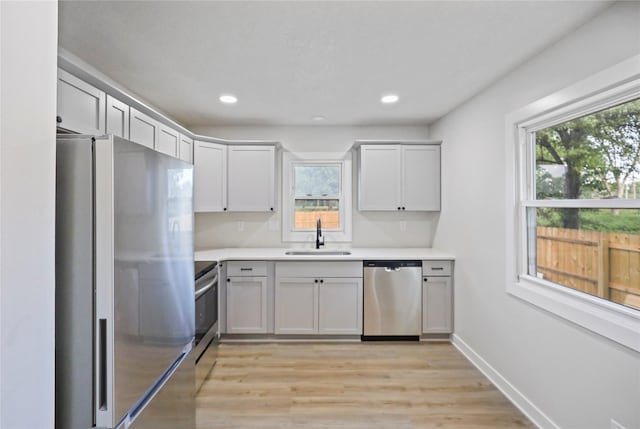 2420 E 37th St, Des Moines, IA 50317 - kitchen with appliances with stainless steel finishes, plenty of natural light, light countertops, light wood-type flooring, and recessed lighting