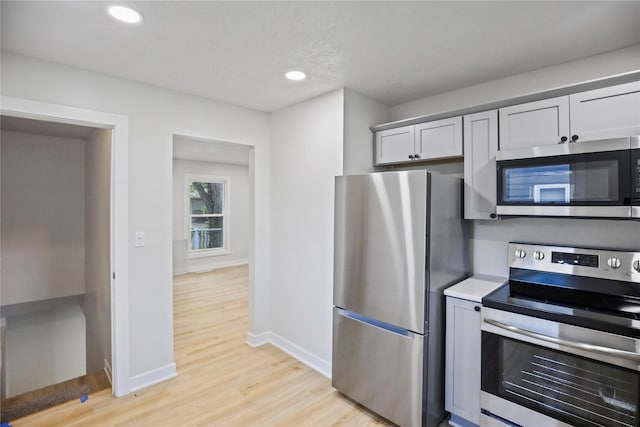 2420 E 37th St, Des Moines, IA 50317 - kitchen with stainless steel appliances, light wood-style floors, light countertops, and recessed lighting