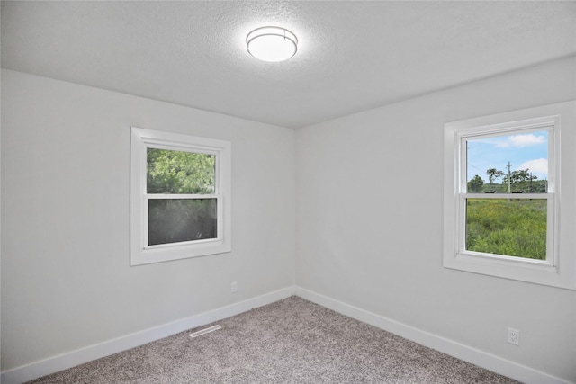 2420 E 37th St, Des Moines, IA 50317 - carpeted empty room featuring baseboards and a textured ceiling