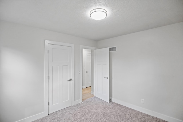 2420 E 37th St, Des Moines, IA 50317 - unfurnished bedroom featuring carpet flooring and a textured ceiling