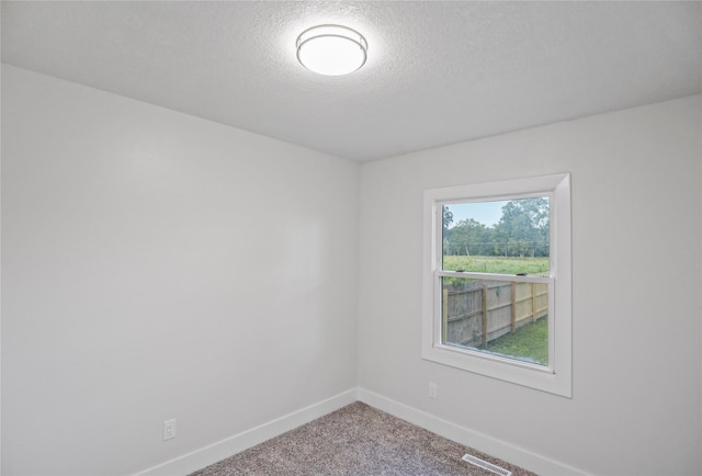 2420 E 37th St, Des Moines, IA 50317 - carpeted empty room with baseboards and a textured ceiling