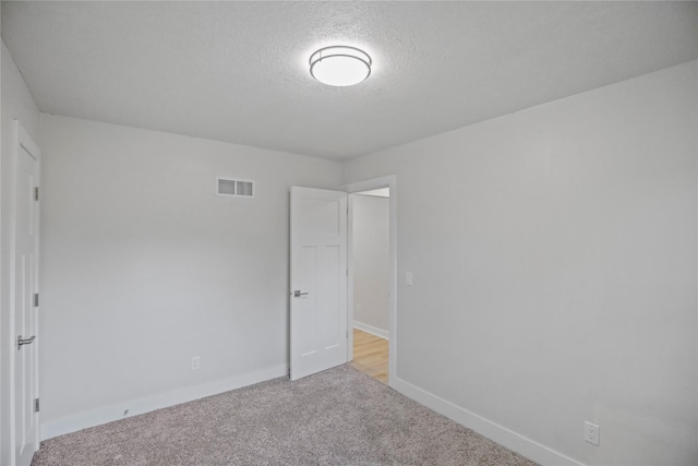 2420 E 37th St, Des Moines, IA 50317 - unfurnished bedroom with light carpet and a textured ceiling