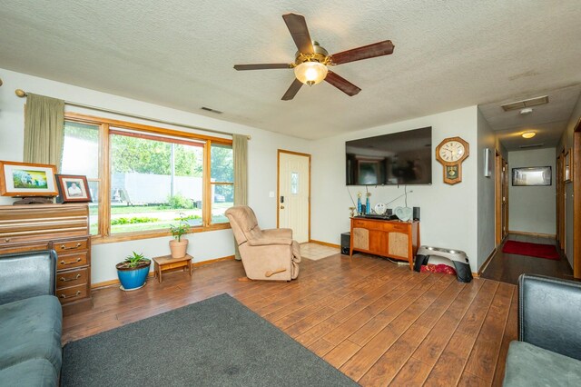 605 Grand St, New Virginia, IA 50210 - living room with wood finished floors, a ceiling fan, and a textured ceiling