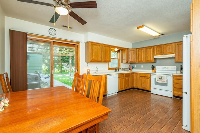 605 Grand St, New Virginia, IA 50210 - kitchen featuring white appliances, under cabinet range hood, dark wood-type flooring, light countertops, and a textured ceiling