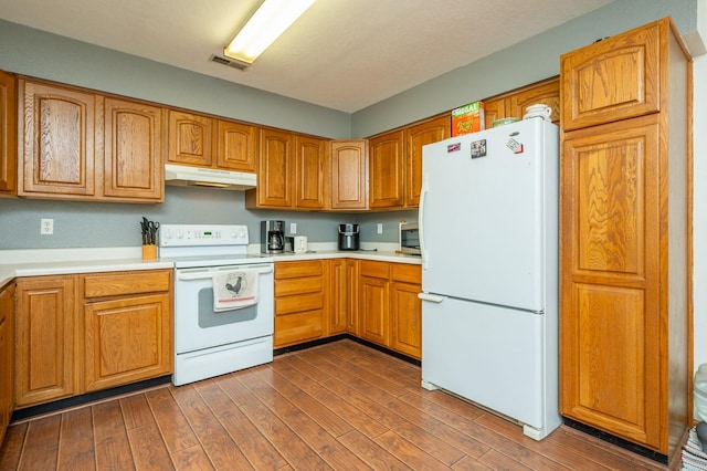 605 Grand St, New Virginia, IA 50210 - kitchen with white appliances, under cabinet range hood, light countertops, dark wood-style floors, and brown cabinets
