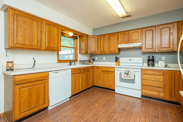 605 Grand St, New Virginia, IA 50210 - kitchen with white appliances, under cabinet range hood, dark wood finished floors, light countertops, and brown cabinets