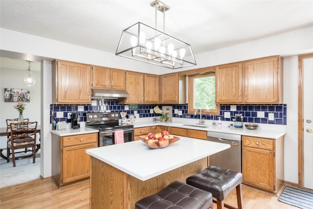 130 SW Meadowlark Ct, Ankeny, IA 50023 - kitchen with appliances with stainless steel finishes, under cabinet range hood, light countertops, and backsplash