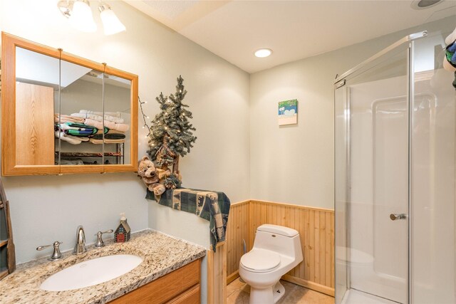130 SW Meadowlark Ct, Ankeny, IA 50023 - bathroom with wainscoting, a stall shower, vanity, and wooden walls