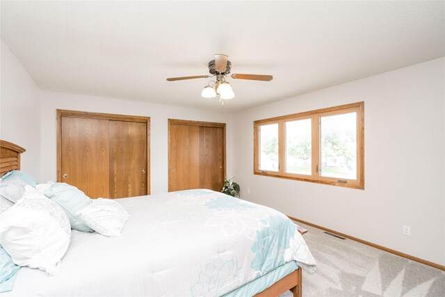130 SW Meadowlark Ct, Ankeny, IA 50023 - bedroom with multiple closets, carpet flooring, and a ceiling fan
