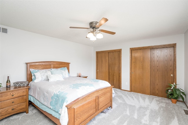 130 SW Meadowlark Ct, Ankeny, IA 50023 - bedroom featuring light carpet, two closets, and a ceiling fan