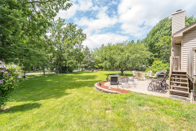 130 SW Meadowlark Ct, Ankeny, IA 50023 - view of grassy yard with a patio, an outdoor fire pit, and view of wooded area