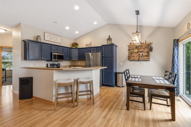 1701 2nd Ave SW, Altoona, IA 50009 - kitchen with appliances with stainless steel finishes, a peninsula, light wood finished floors, vaulted ceiling, and a breakfast bar