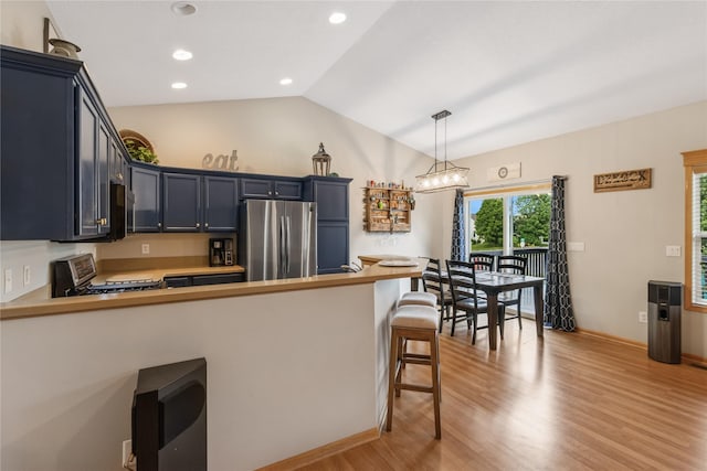 1701 2nd Ave SW, Altoona, IA 50009 - kitchen featuring freestanding refrigerator, range, light wood-style flooring, lofted ceiling, and a peninsula