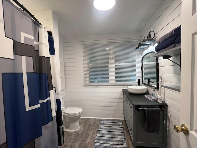 109 E Jackson St, Panora, IA 50216 - bathroom with vanity, wood finished floors, wooden walls, and a shower with shower curtain