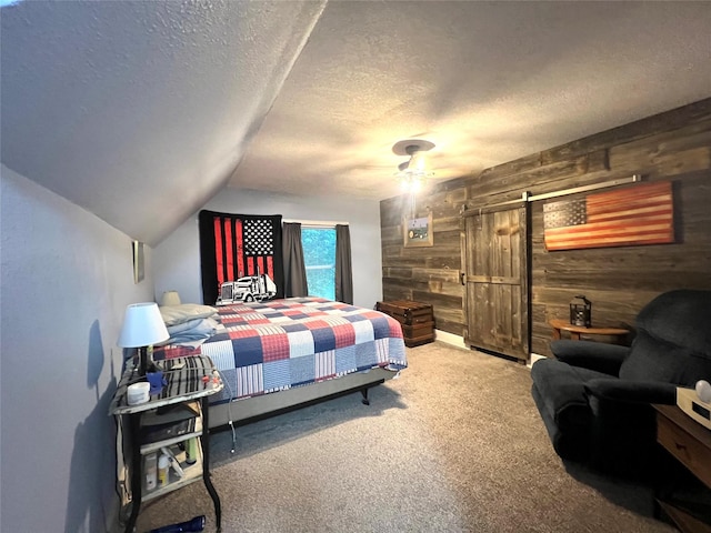 109 E Jackson St, Panora, IA 50216 - bedroom with wood walls, carpet, a textured ceiling, a barn door, and lofted ceiling