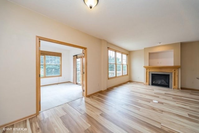 8318 Boulder Dr, West Des Moines, IA 50266 - unfurnished living room featuring light wood-style floors and a glass covered fireplace