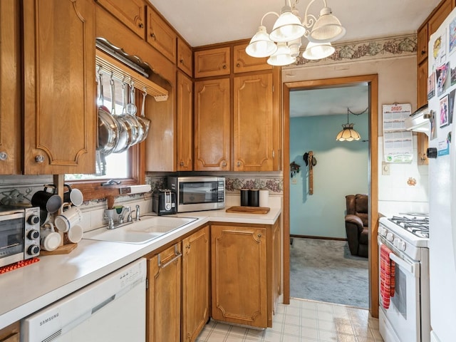 2400 Farwell Rd, Des Moines, IA 50317 - kitchen with white appliances, a chandelier, light countertops, brown cabinets, and backsplash