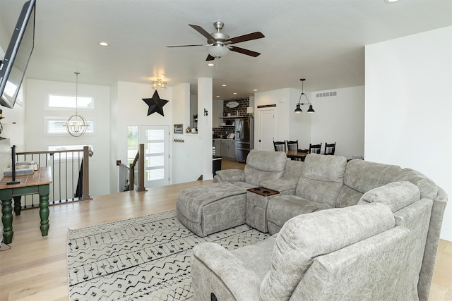 309 NW Beechwood Dr, Grimes, IA 50111 - living area featuring a ceiling fan, light wood finished floors, a chandelier, and recessed lighting