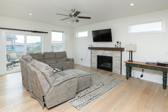 309 NW Beechwood Dr, Grimes, IA 50111 - living area with a ceiling fan, light wood finished floors, a stone fireplace, and recessed lighting