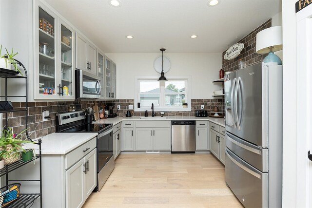 309 NW Beechwood Dr, Grimes, IA 50111 - kitchen with stainless steel appliances, light wood finished floors, tasteful backsplash, recessed lighting, and light countertops