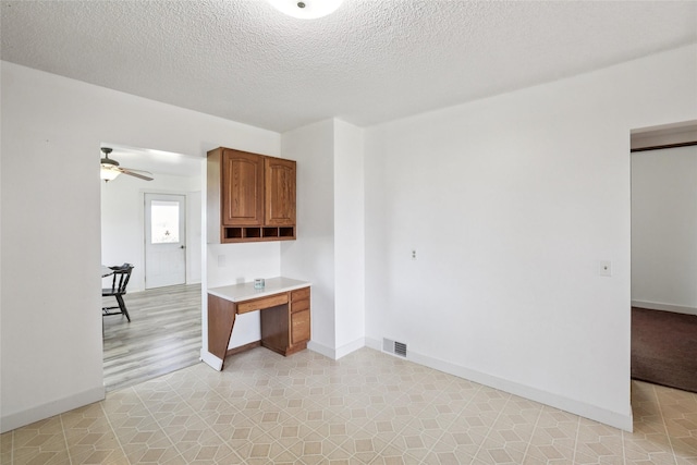 7404 Sioux Ave, Reasnor, IA 50232 - spare room with ceiling fan, a textured ceiling, and an office area