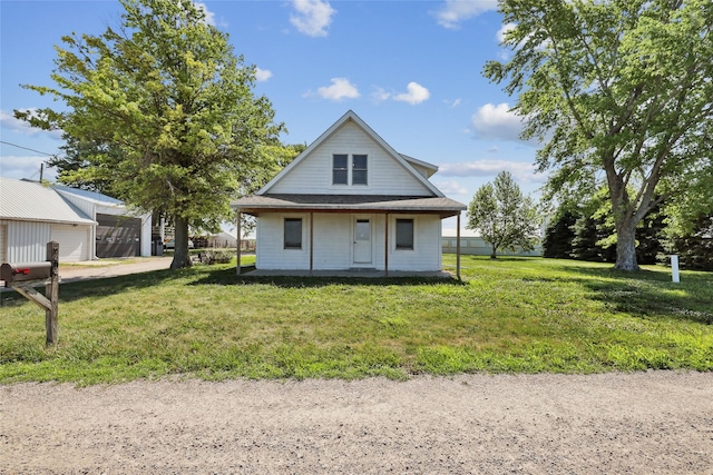 7404 Sioux Ave, Reasnor, IA 50232 - view of front of home with a detached garage, a front yard, and covered porch
