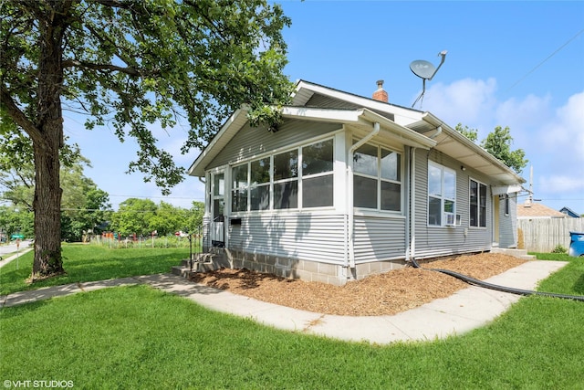 1547 13th St, Des Moines, IA 50314 - view of side of home featuring a chimney and a sunroom