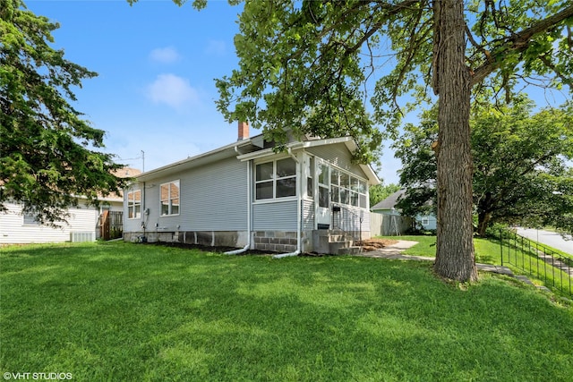 1547 13th St, Des Moines, IA 50314 - view of side of property featuring a chimney, a sunroom, and entry steps