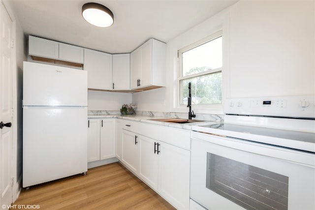 1547 13th St, Des Moines, IA 50314 - kitchen featuring freestanding refrigerator, white cabinets, and light wood-style flooring
