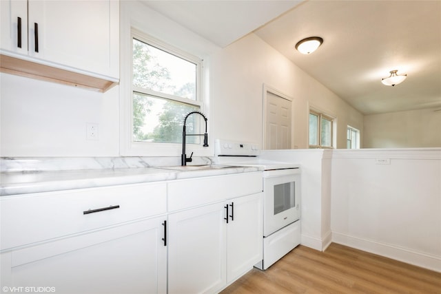 1547 13th St, Des Moines, IA 50314 - kitchen featuring white range with electric stovetop, light wood-type flooring, and white cabinets