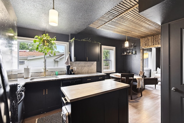 1315 Bundy St, Des Moines, IA 50315 - kitchen featuring wood counters, dark cabinets, light wood-style floors, range with gas stovetop, and pendant lighting