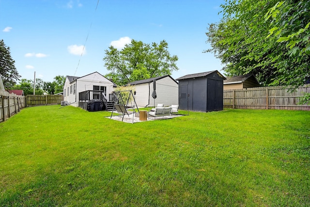 1315 Bundy St, Des Moines, IA 50315 - fenced backyard with a storage unit, outdoor lounge area, a deck, and a patio