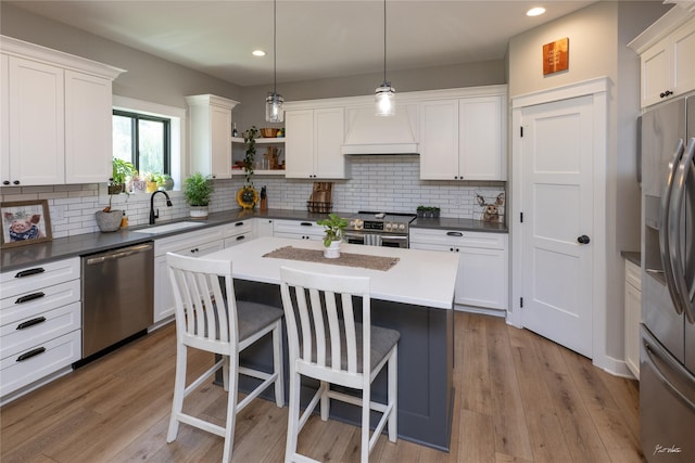 807 W Orchard Ave, Indianola, IA 50125 - kitchen with stainless steel appliances, premium range hood, a kitchen breakfast bar, recessed lighting, and open shelves