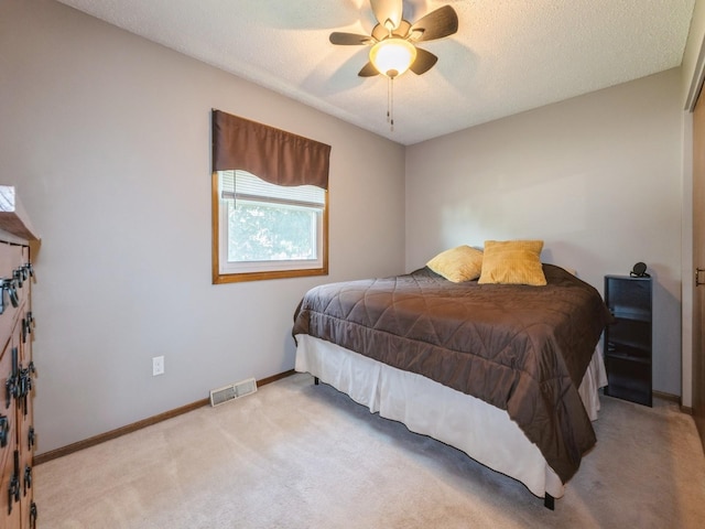 808 SW 2nd St, Stuart, IA 50250 - carpeted bedroom featuring a textured ceiling and a ceiling fan