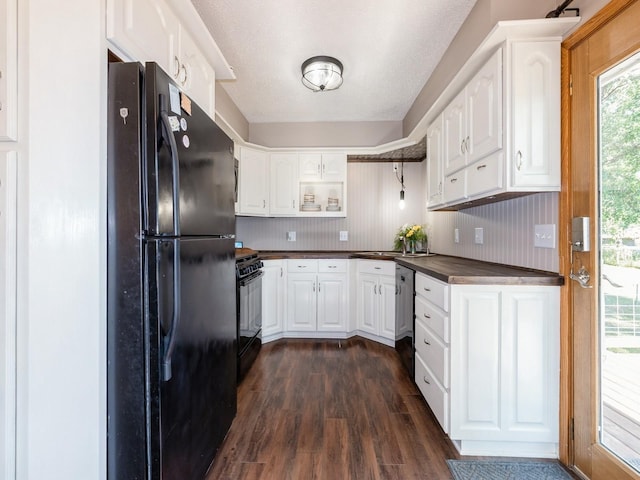 808 SW 2nd St, Stuart, IA 50250 - kitchen with black appliances, dark countertops, dark wood-type flooring, and white cabinetry