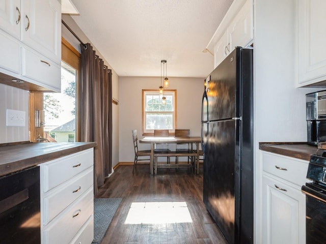 808 SW 2nd St, Stuart, IA 50250 - kitchen featuring black appliances, dark wood-type flooring, white cabinets, pendant lighting, and wooden counters