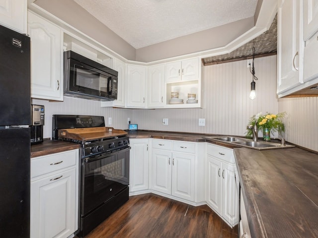 808 SW 2nd St, Stuart, IA 50250 - kitchen featuring black appliances, butcher block countertops, dark wood-style floors, white cabinetry, and a textured ceiling