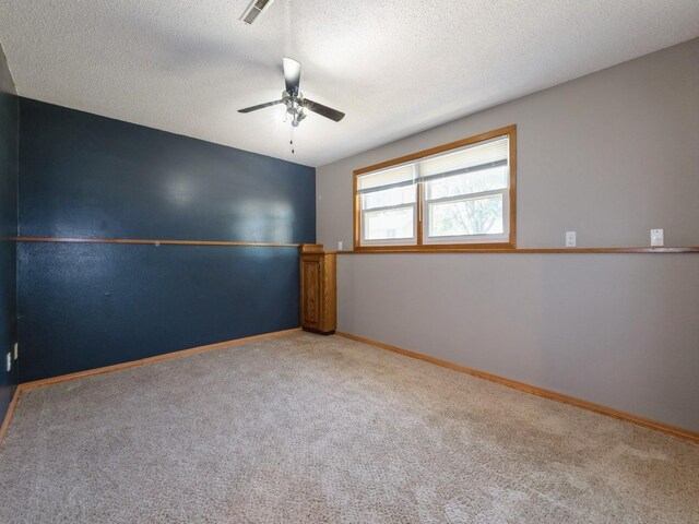 808 SW 2nd St, Stuart, IA 50250 - carpeted spare room with a ceiling fan and a textured ceiling