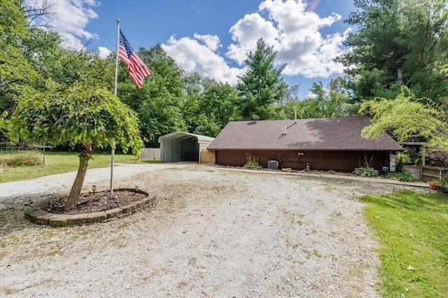 407 E Mckinney St, Runnells, IA 50237 - view of side of property with a carport, driveway, a lawn, and view of scattered trees