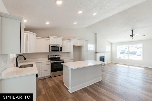 826 31st Ct SW, Altoona, IA 50009 - kitchen featuring stainless steel appliances, healthy amount of natural light, white cabinets, lofted ceiling, and light countertops