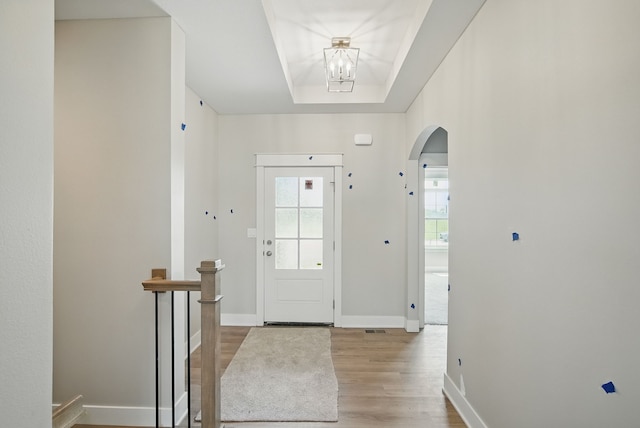 45 NW Alderleaf Dr, Waukee, IA 50263 - entrance foyer with healthy amount of natural light, arched walkways, wood finished floors, and a chandelier