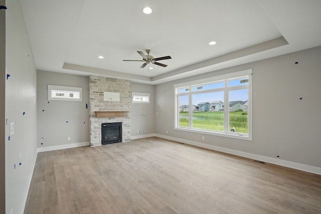 45 NW Alderleaf Dr, Waukee, IA 50263 - unfurnished living room featuring a tray ceiling, ceiling fan, healthy amount of natural light, light wood-style floors, and recessed lighting