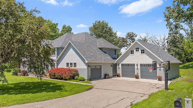 54 Four Winds Dr, Clear Lake, IA 50428 - view of front of property featuring board and batten siding, a front lawn, roof with shingles, and asphalt driveway